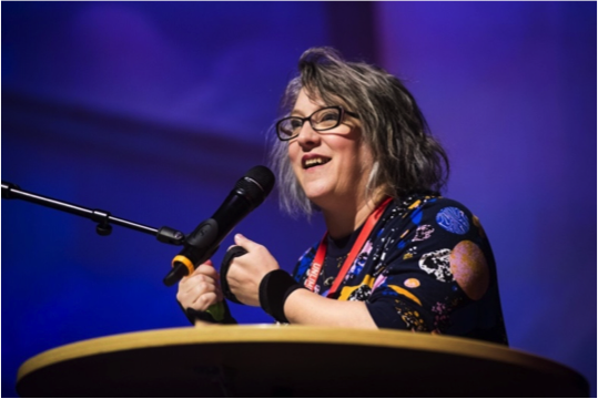 Jo Verrent speaks into a microphone at a podium